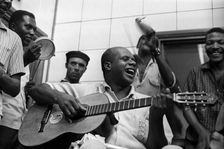 Candeia on the guitar in 1969, with Martinho da Vila behind him.